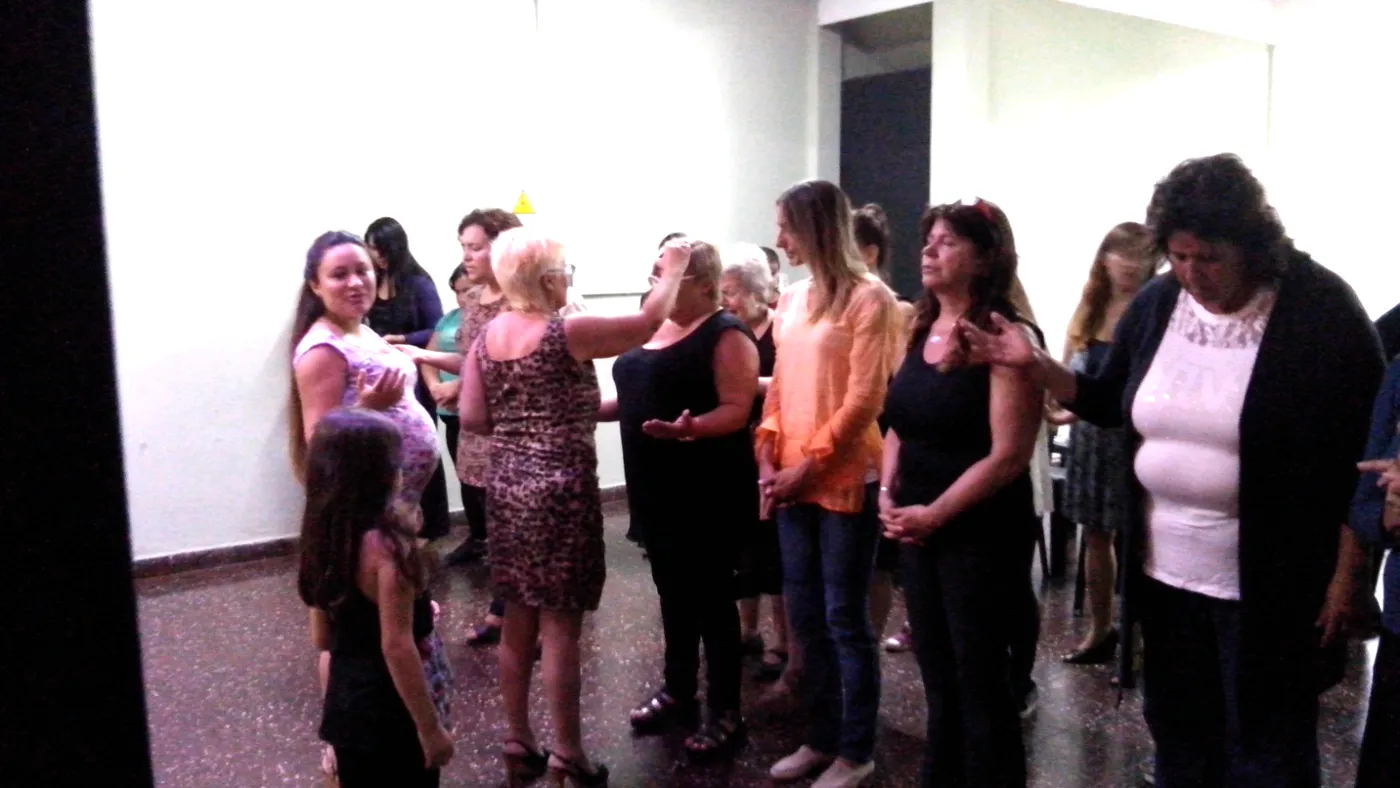 Mujeres de la congregación orando unas por otras