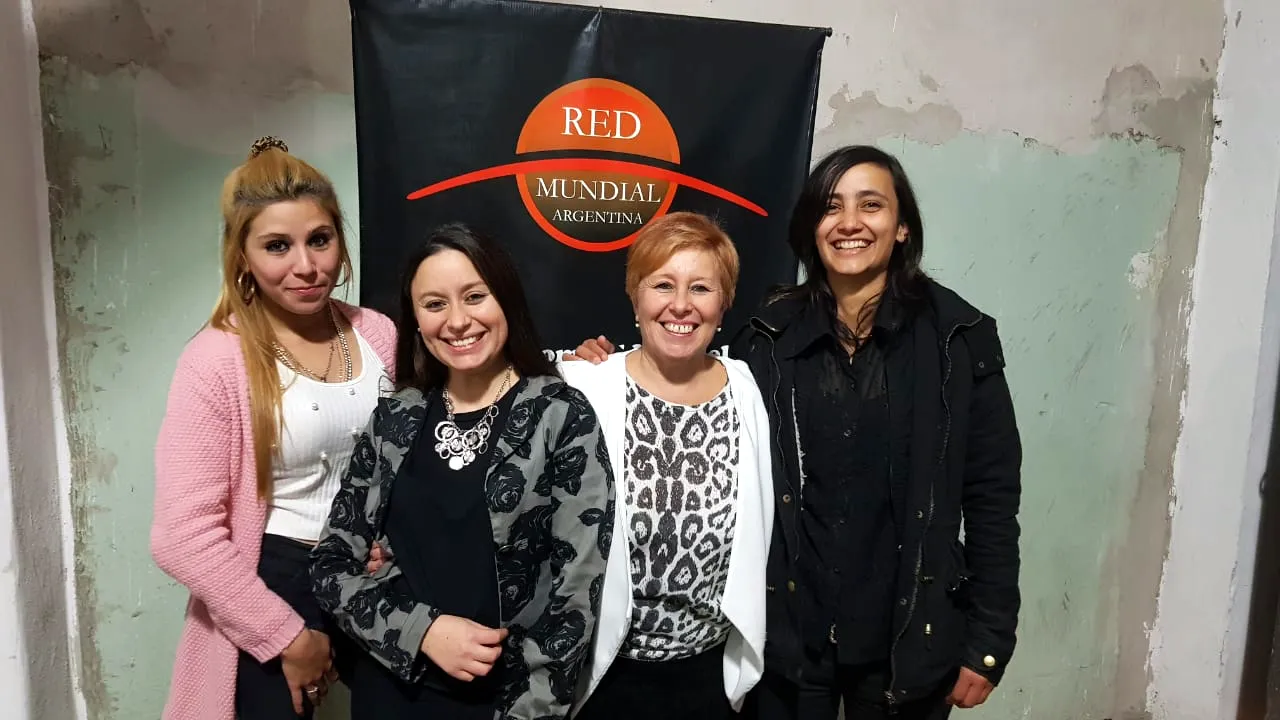 Servidoras de Mujeres de Hierro junto al banner de Red Mundial